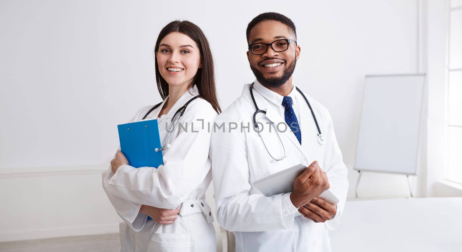 Diverse Professional Doctors In White Coats Posing To Camera At Conference Room