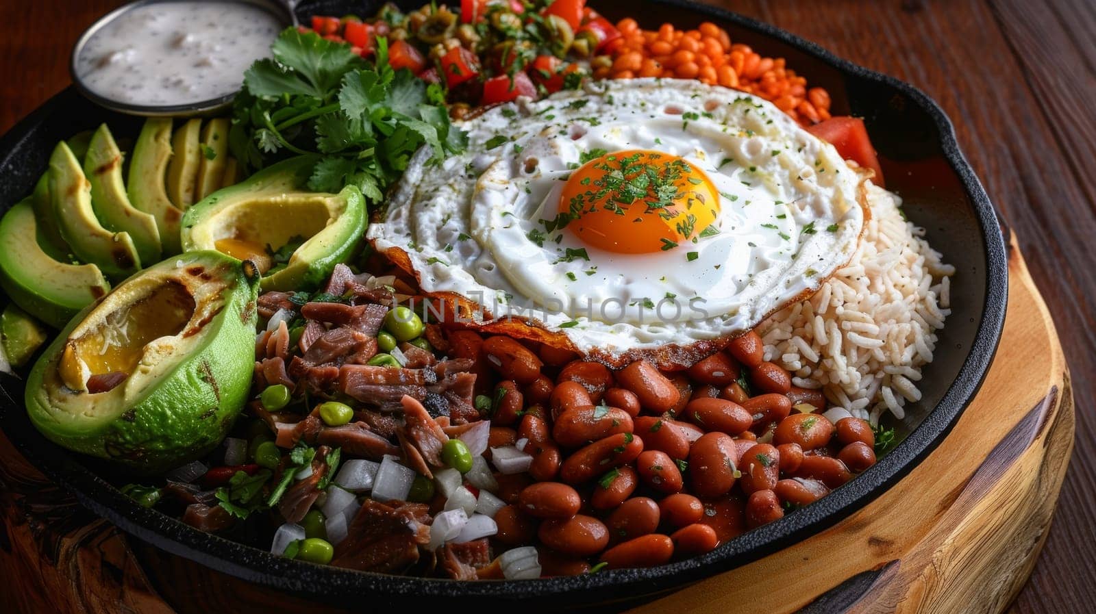 Bandeja paisa, a traditional Colombian platter featuring a hearty and flavorful assortment of beans, rice, pork, avocado, and a fried egg, presented on a large round dish
