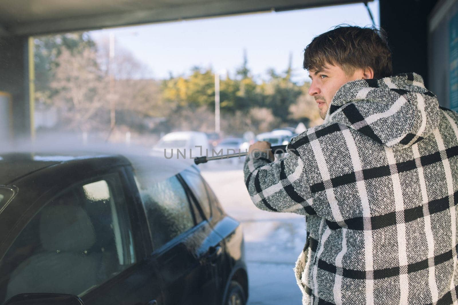 Cleaning car using active foam. Man washing his car on self car-washing. by malyshph