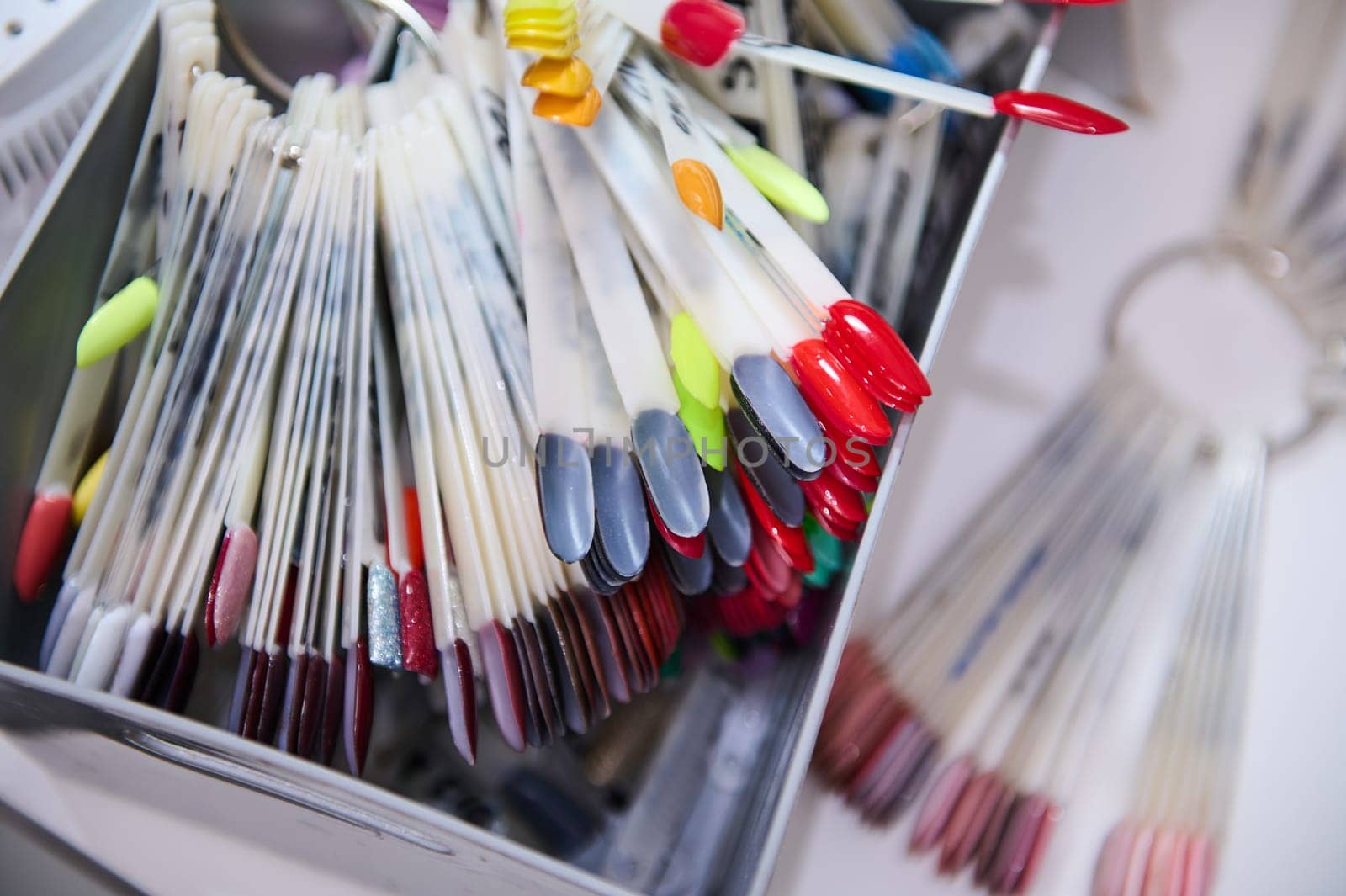 Colorful nail polish samples in a beauty salon box by artgf