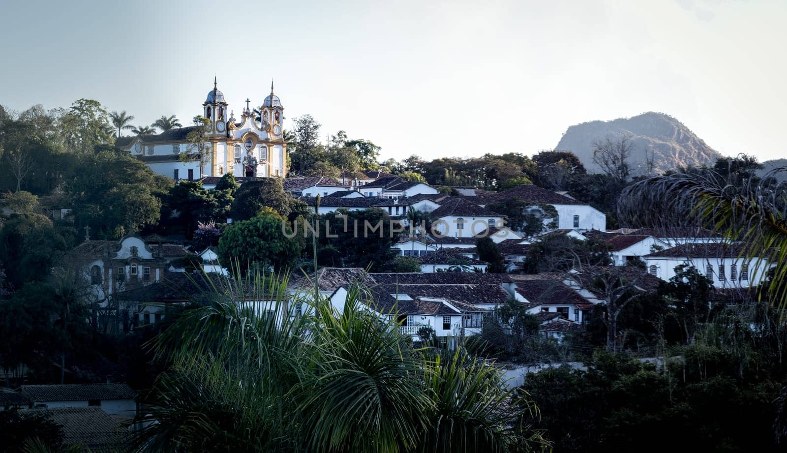 A tranquil scene of a historic colonial town encircled by lush tropical greenery.