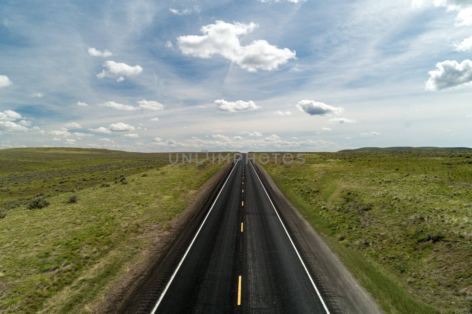 aerial view of a road with clouds in the background