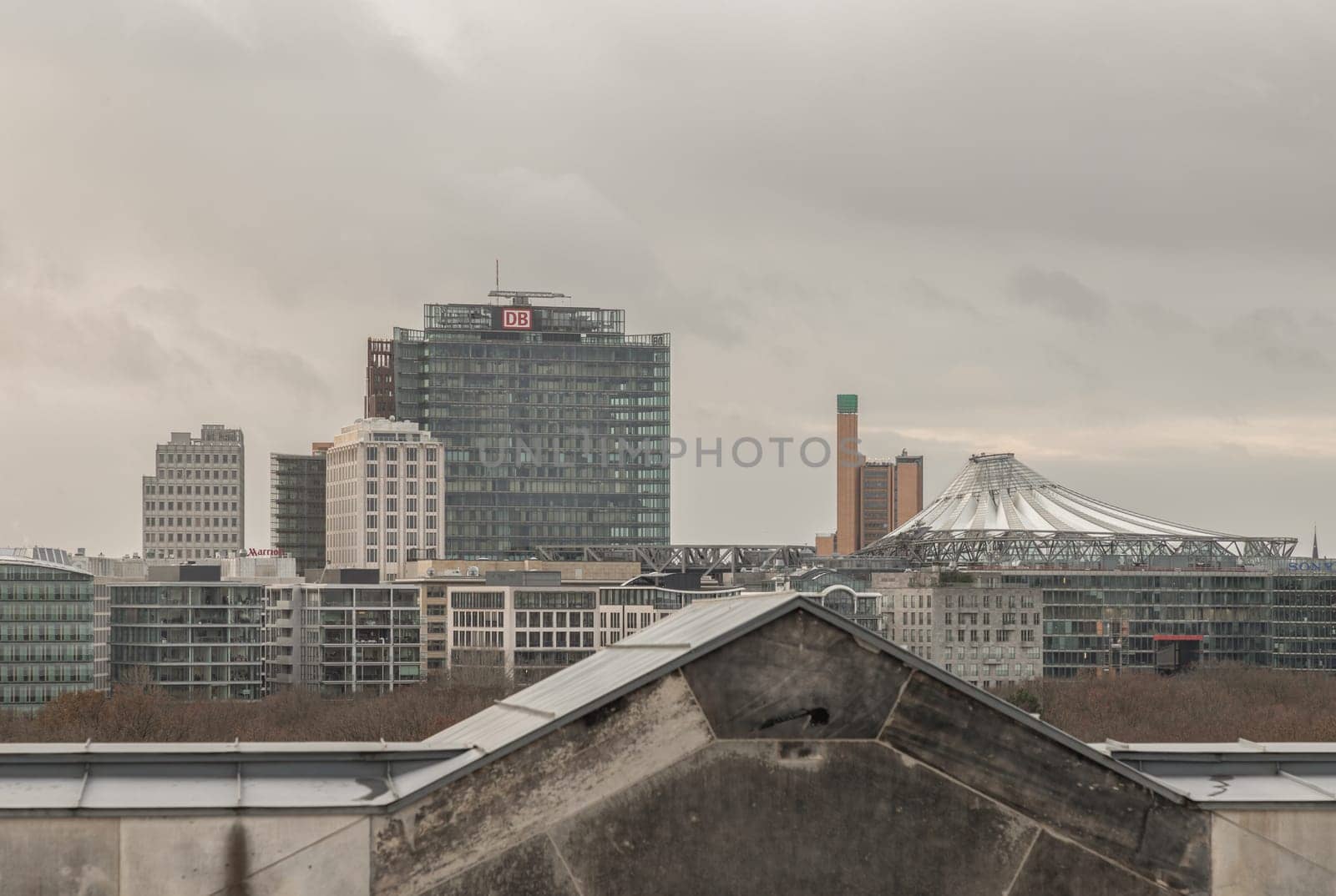 Berlin, Germany - Dec 20, 2023 - Berlin cityscape view from above of Reichstag building with Deutsche Bahn building, Potsdamer Platz (Sony Center) and buildings at the downtown Berlin. a major tourist attraction of the berlin city, Space for text, Selective focus.