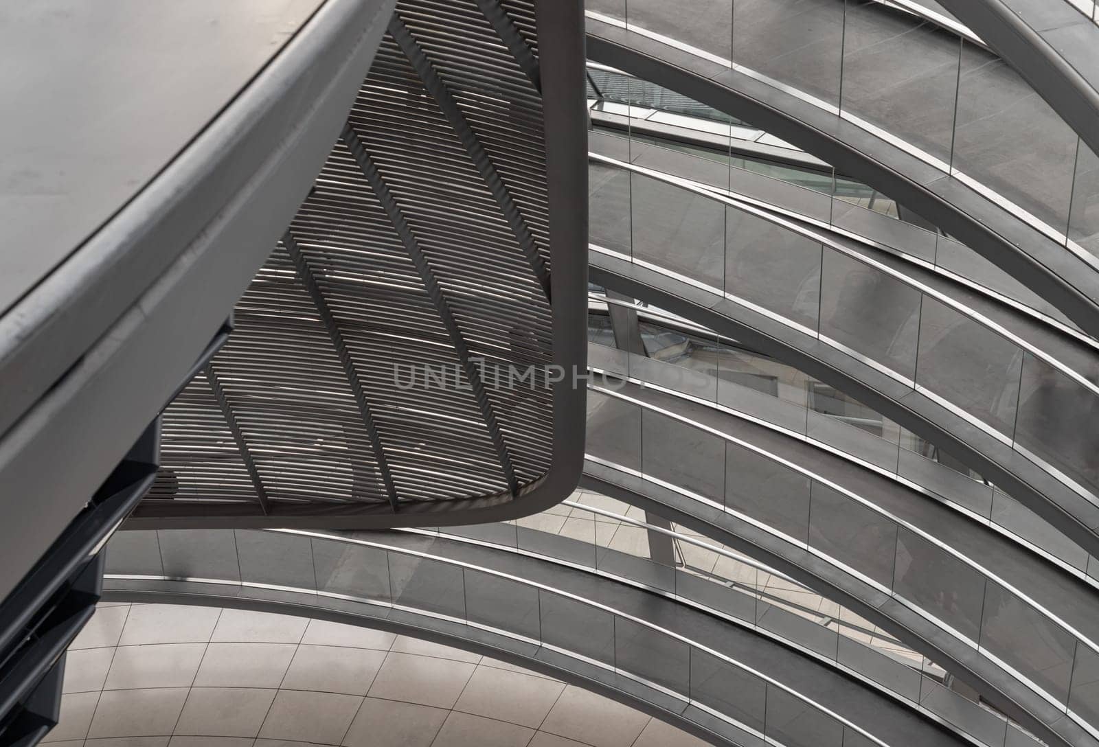 Berlin, Germany - Dec 20, 2023 - A curved walkway stretches in spirals upwards on top inside the glass dome constructed of the Reichstag building. Contemporary architecture of the Cupola of the Reichstag dome, a major tourist attraction of the berlin city, Space for text, Selective focus.