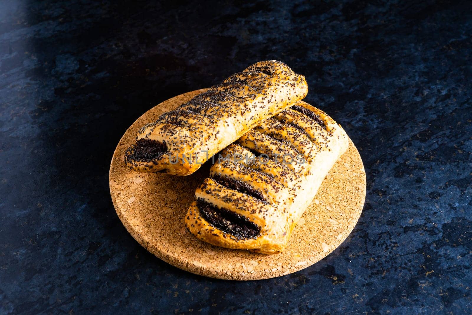 Freshly backed french croissant shiny in the rays of morning sun, dark background, kitchen