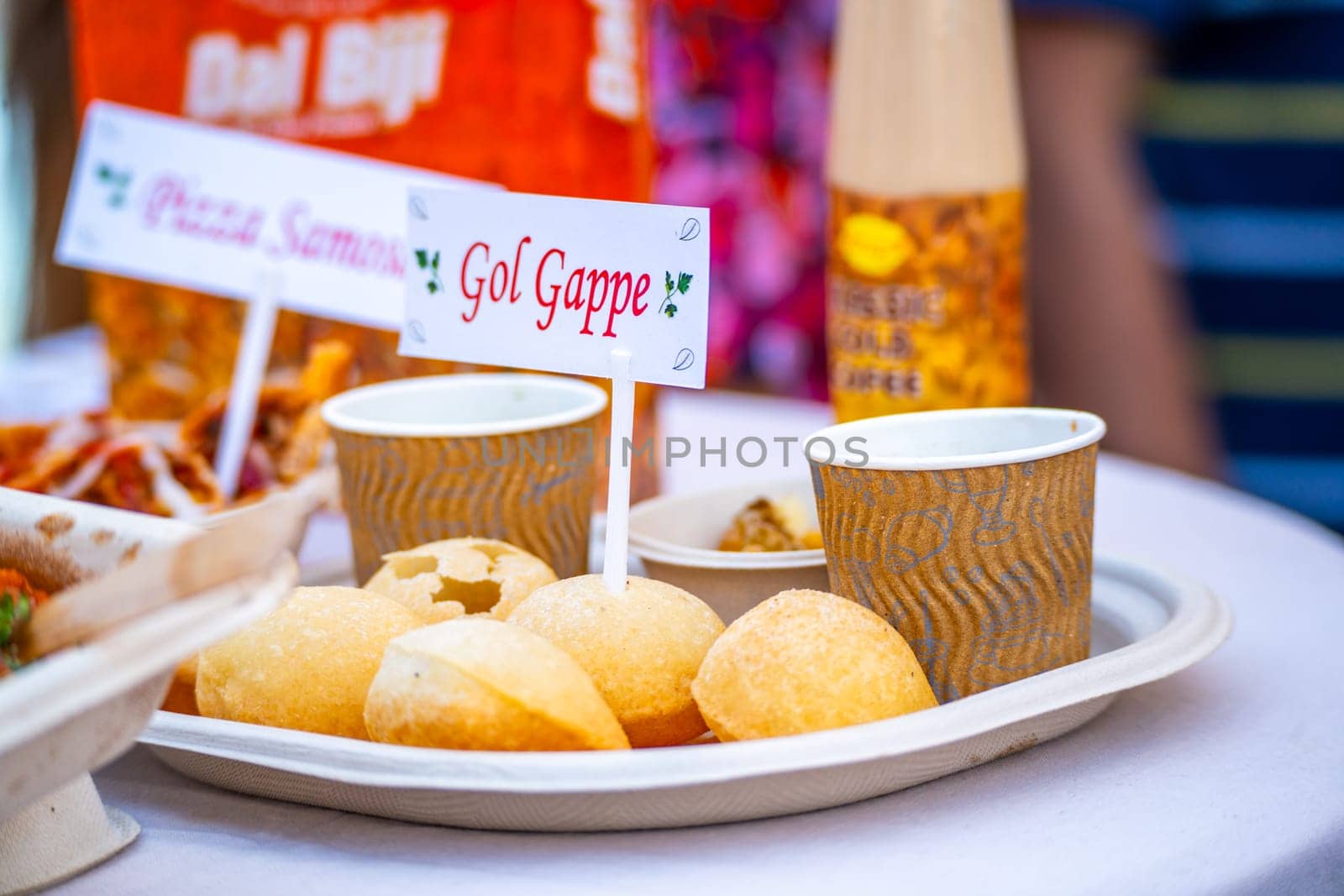 disposable plate with gol gappe tag on it showing this popular snack of puffed flour balls filled with spicy water and potatoes in india