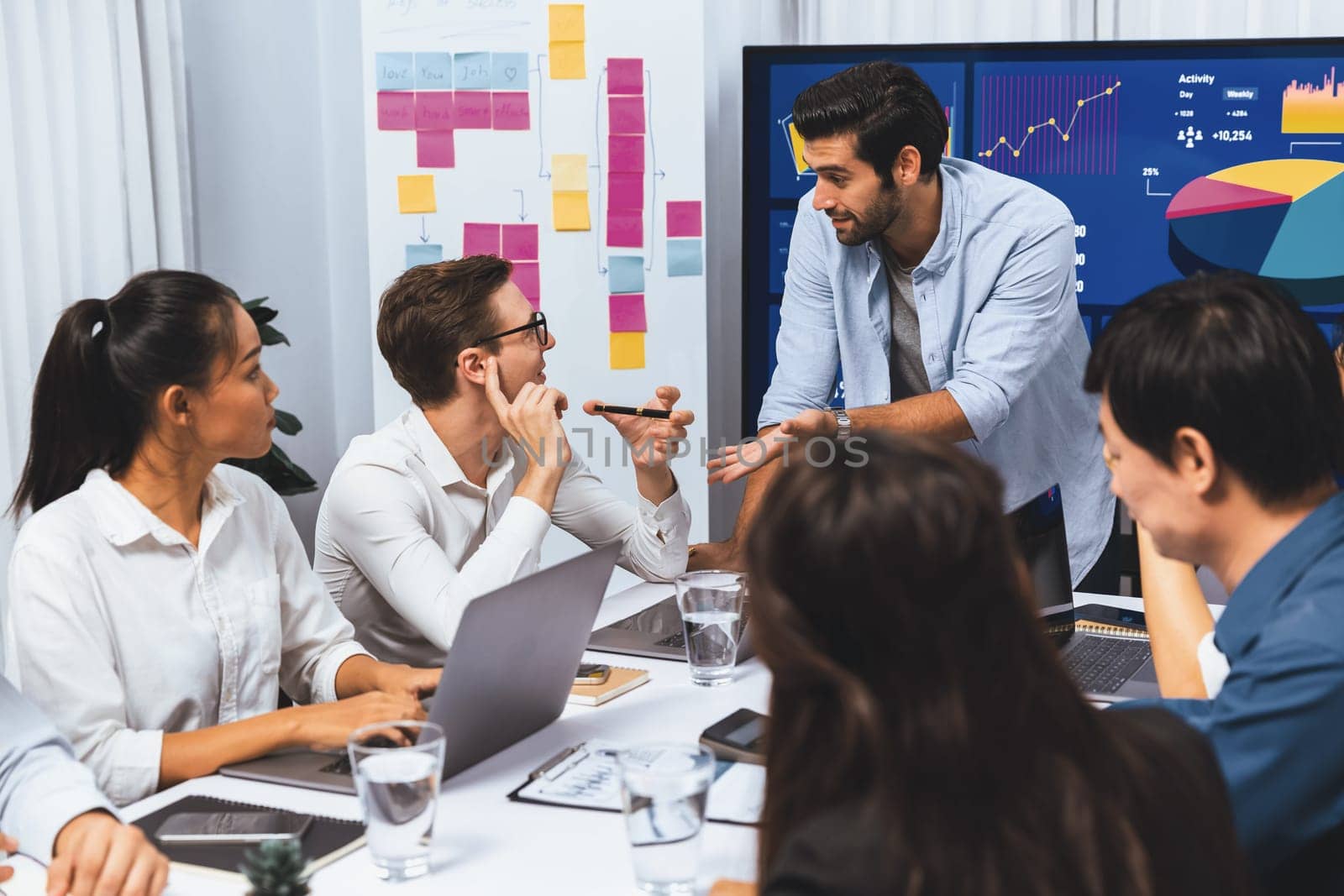 Analyst team utilizing BI Fintech to analyze financial data at table in meeting room. Businesspeople analyzing BI dashboard power for business insight and strategic marketing planning. Prudent