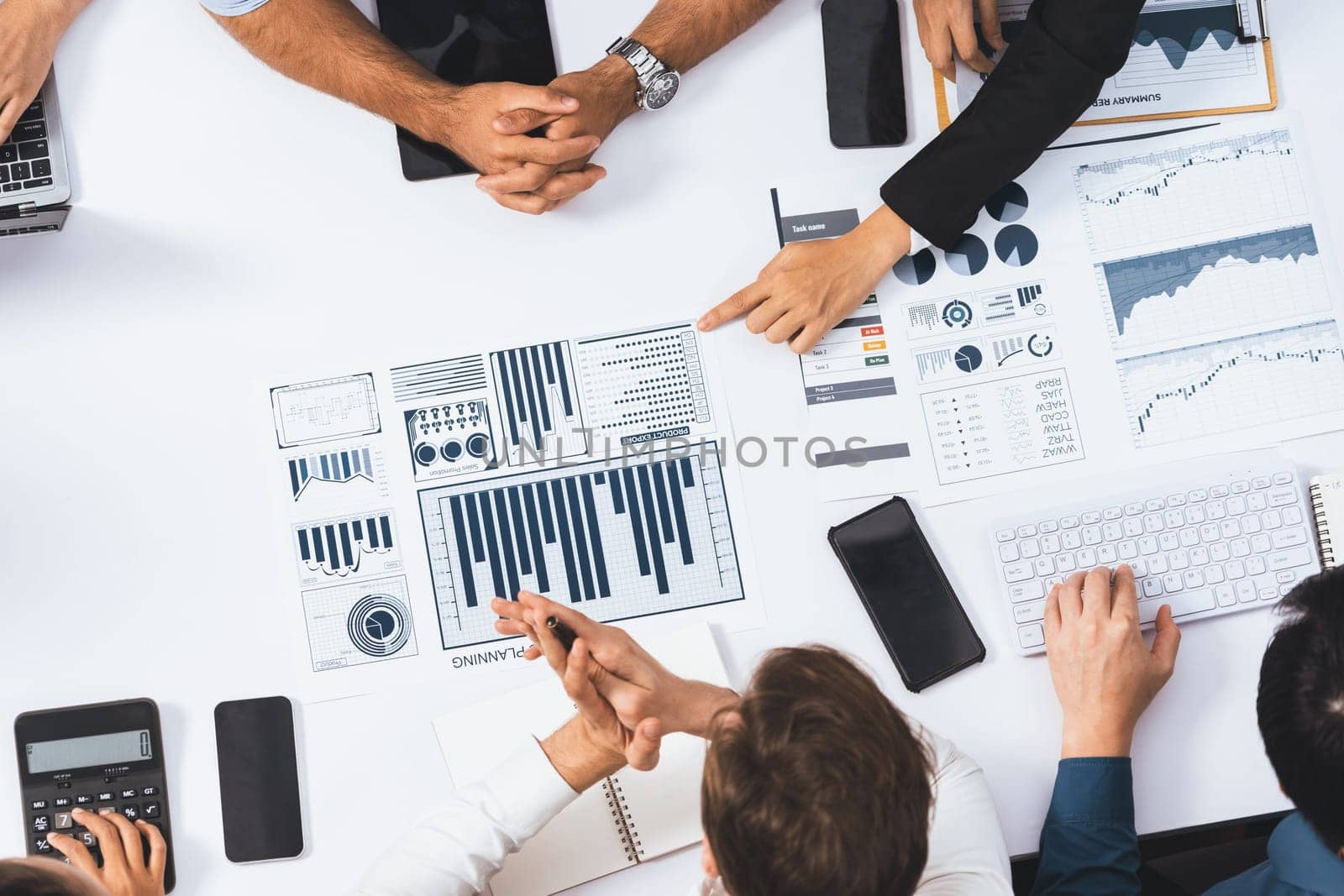 Top view analyst team utilizing BI Fintech to analyze financial data at table in meeting room. Analytic BI dashboard power on paper for business insight and strategic marketing planning. Prudent