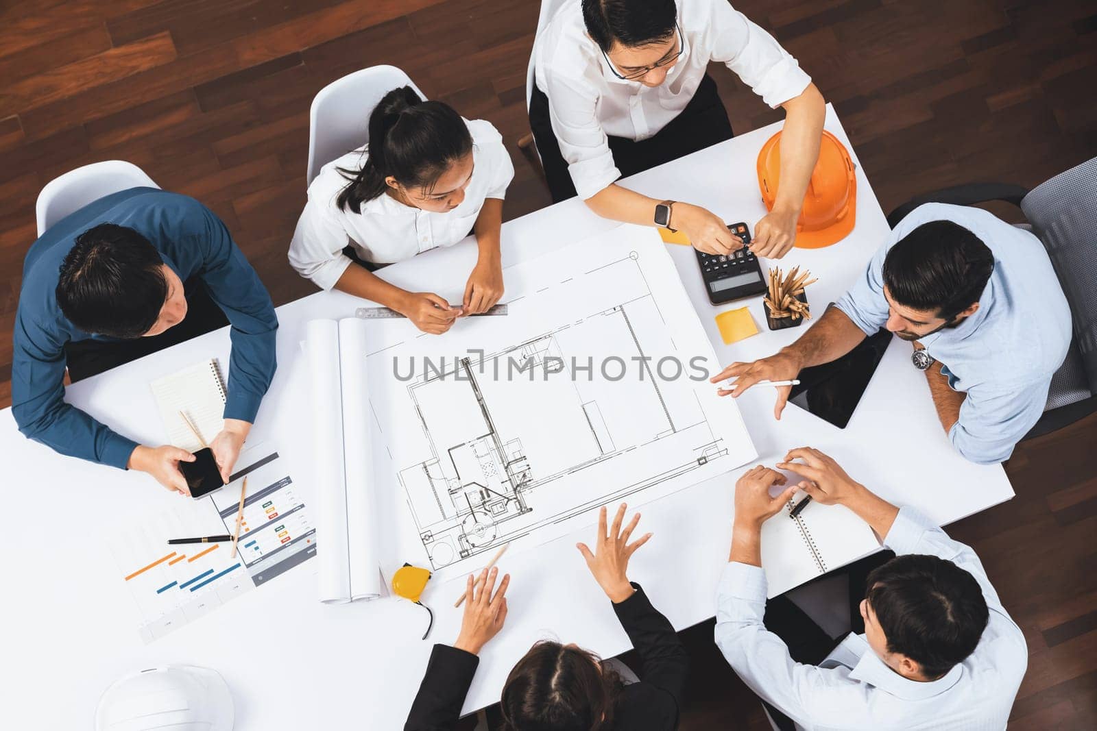 Top view banner of diverse group of civil engineer and client working together on architectural project, reviewing construction plan and building blueprint at meeting table. Prudent