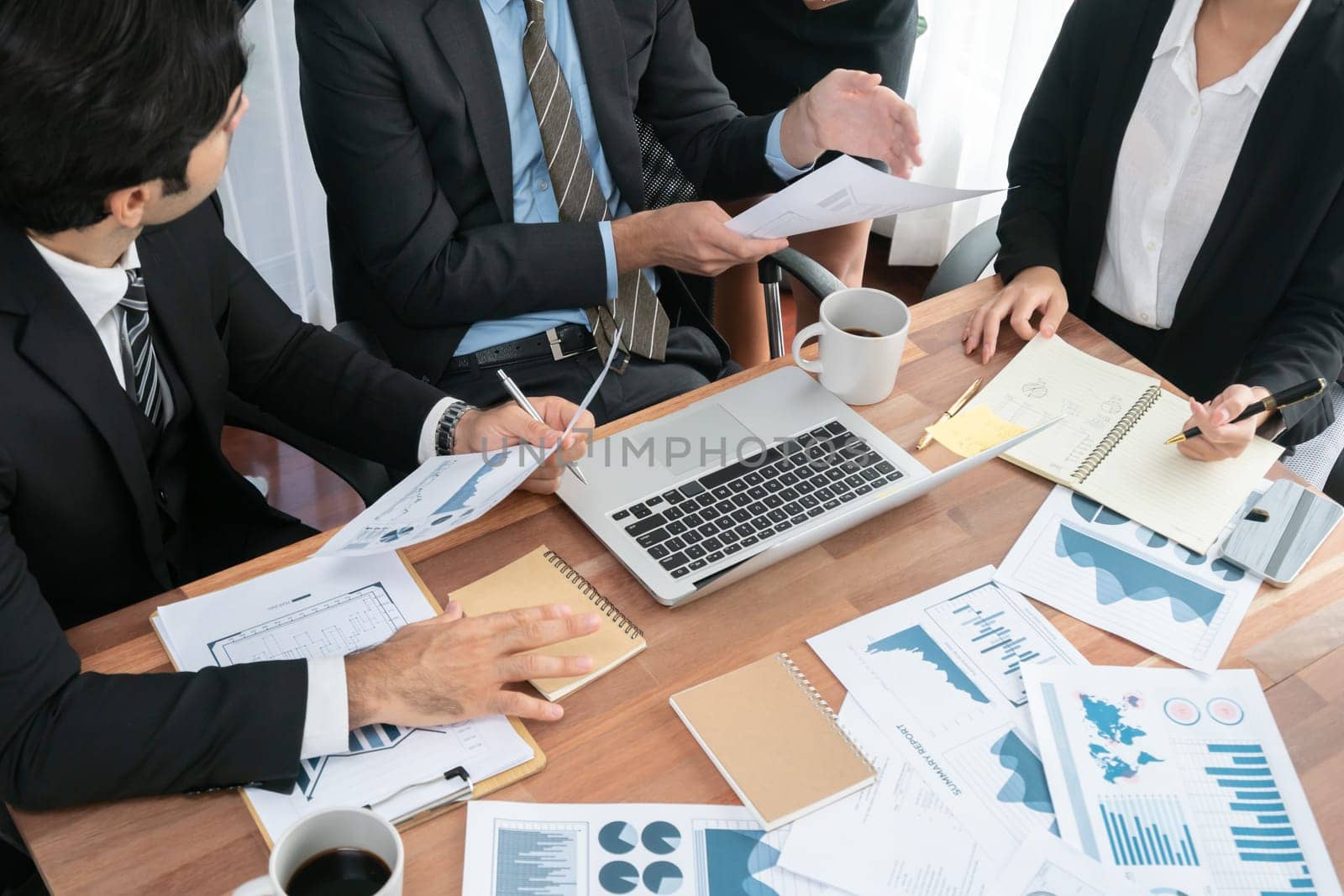 Diverse group of business analyst team analyzing financial data report paper on office table. Chart and graph dashboard by business intelligence analysis for strategic marketing planning Habiliment