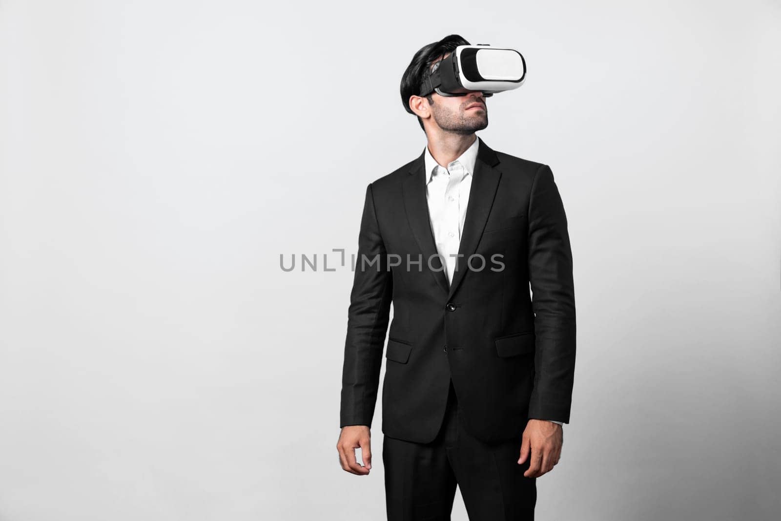 Skilled project manager with VR glasses standing and looking around. Caucasian businessman connecting with metaverse and virtual reality world while wearing suit. Innovation technology. Deviation.