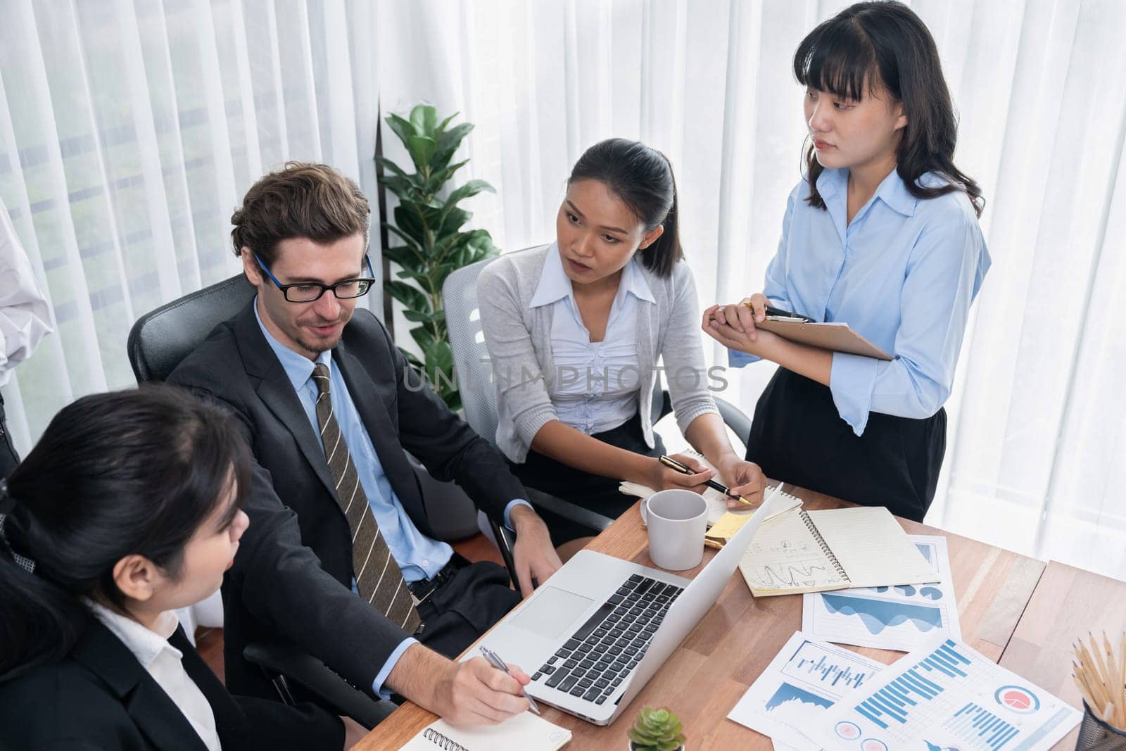 Diverse group of business analyst team analyzing financial data report paper on office table. Chart and graph dashboard by business intelligence analysis for strategic marketing planning Meticulous