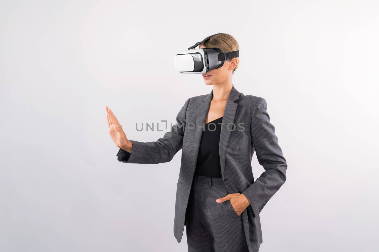 Smart business woman touching something while look though VR glass. Skilled project manager wearing suit and innovation technology visual reality goggles for connecting with metaverse. Contraption.