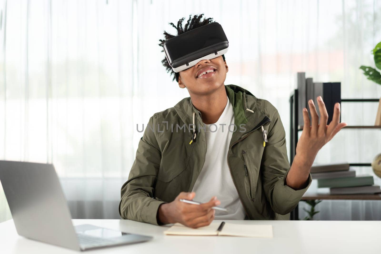 Young African American studying through VR glasses online course meeting hologram looking metaverse world connecting digital futuristic technology virtual reality at meta modern office. Contrivance.