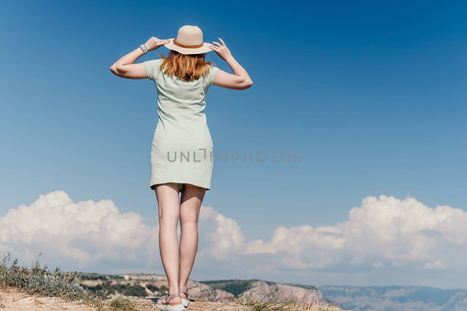 Woman travel sea. Happy tourist in hat enjoy taking picture outdoors for memories. Woman traveler posing on the beach at sea surrounded by volcanic mountains, sharing travel adventure journey by panophotograph