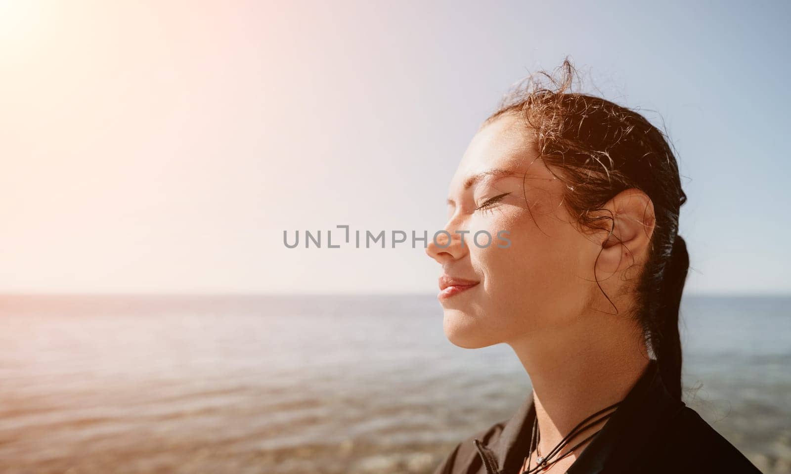 Woman travel sea. Young Happy woman posing on a beach near the sea on background of volcanic rocks, like in Iceland, sharing travel adventure journey