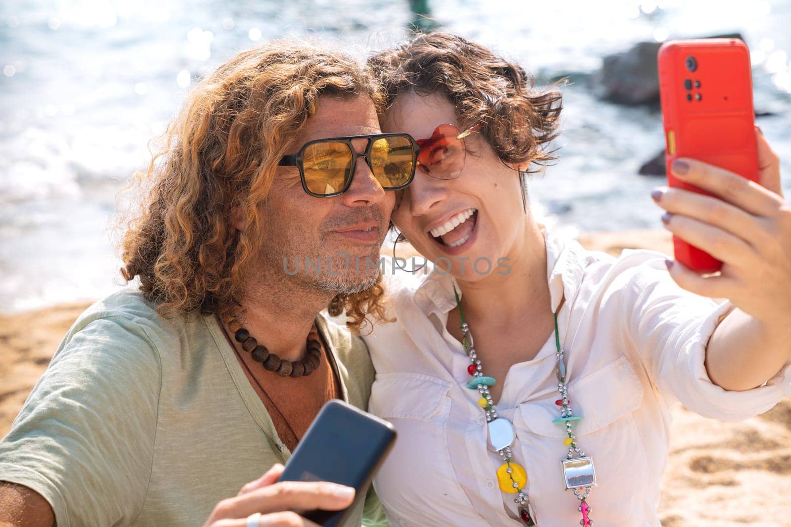 Happy couple takes a selfie together with smartphone on the beach by molesjuny