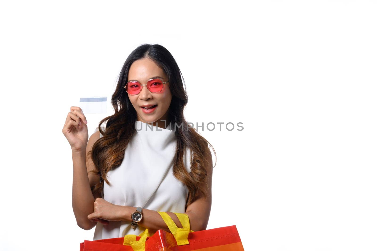 Portrait of beautiful woman standing isolated over white background and showing credit card by prathanchorruangsak