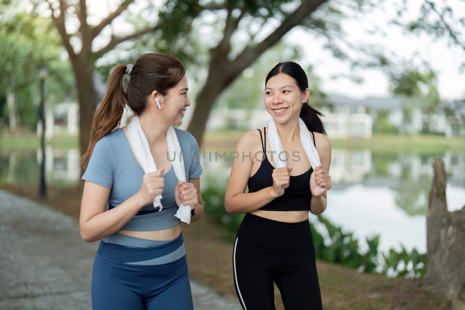 Two young women running together in a park during the morning, enjoying exercise and promoting a healthy lifestyle.