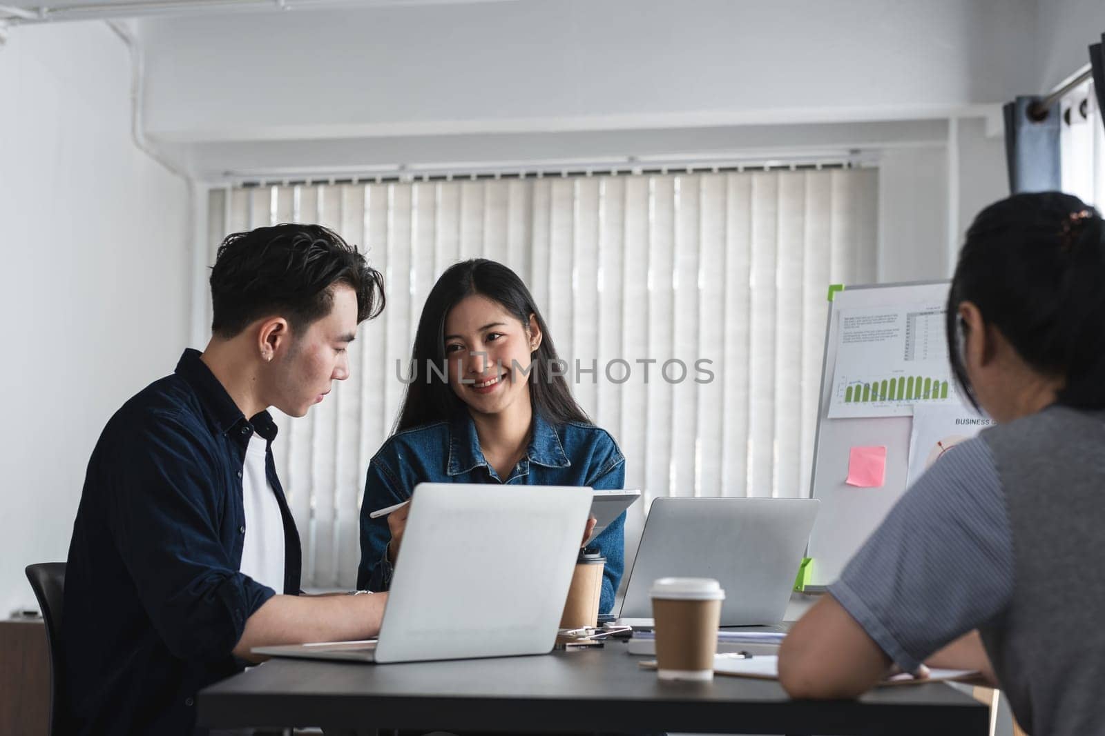 Team of Business Professionals Engaging in a Productive Discussion and Sharing Ideas in a Modern Office Setting by wichayada