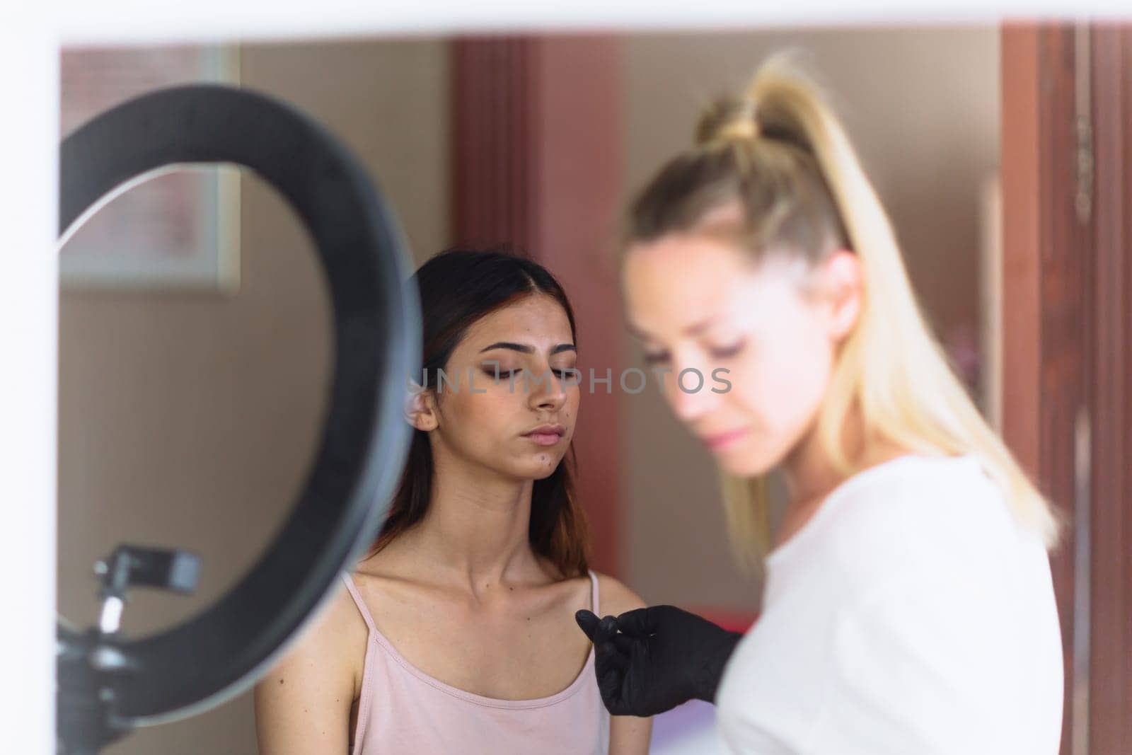 Makeup woman artist at work, professional in action with young model in beauty salon and creative classes