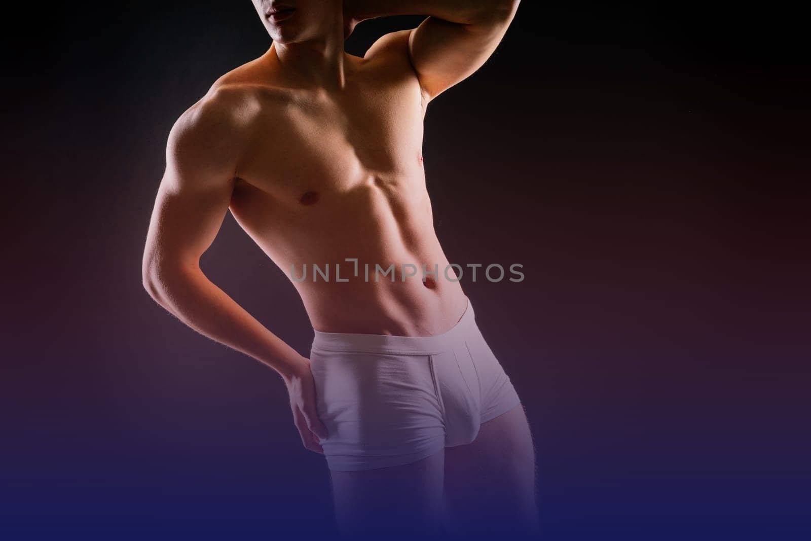 Man holds barbell weights, young adult strong male in a white briefs, studio shot. Sport and muscles.