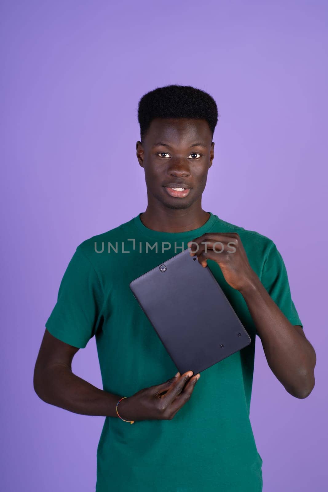 Man in Green Shirt Holding Laptop by Ceballos