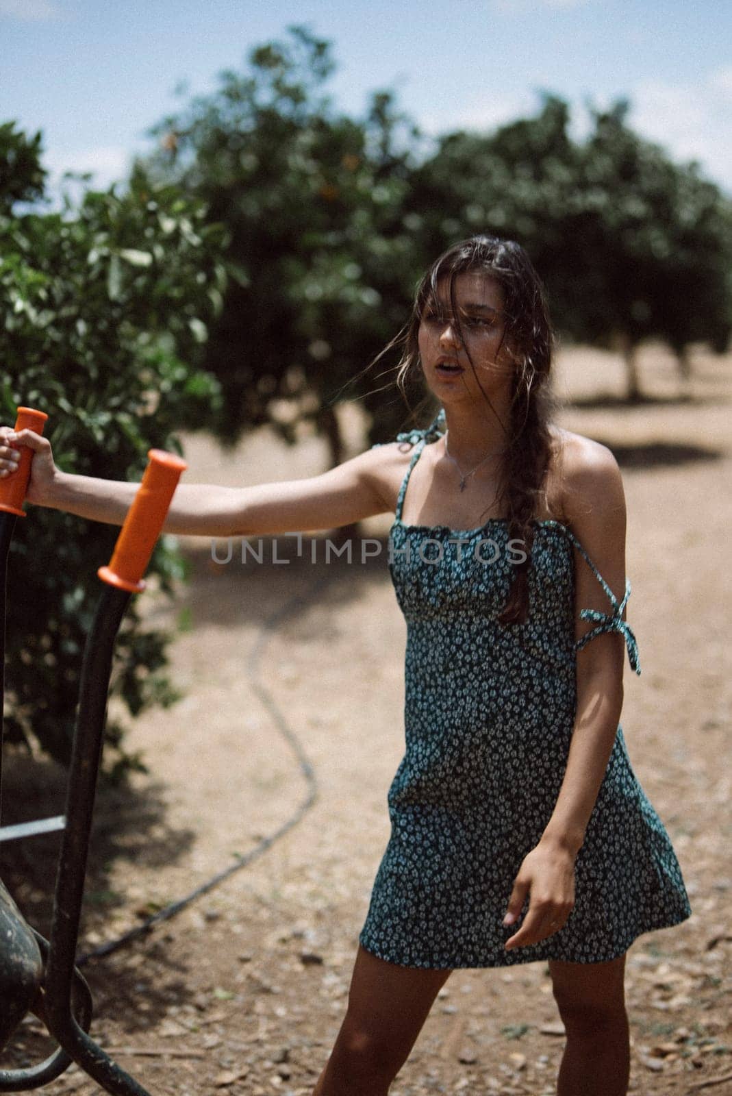 A young woman in a beautiful blue dress enjoys a sunny day outdoors, showing a sense of freedom and joy in nature