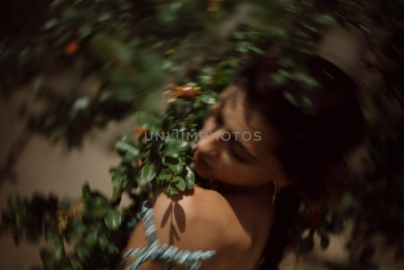 A woman surrounded by leaves and berries, with a dreamy focus effect, creating an airy, artistic and ethereal vibe