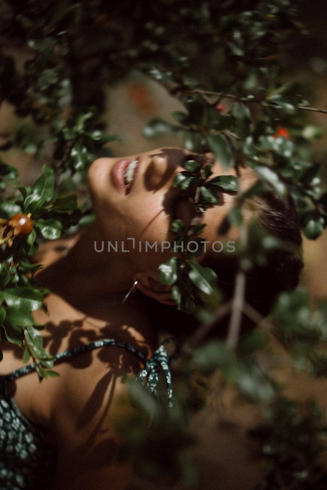 In the closeup shot, a woman is surrounded by foliage, evoking tranquility and deep connection with nature