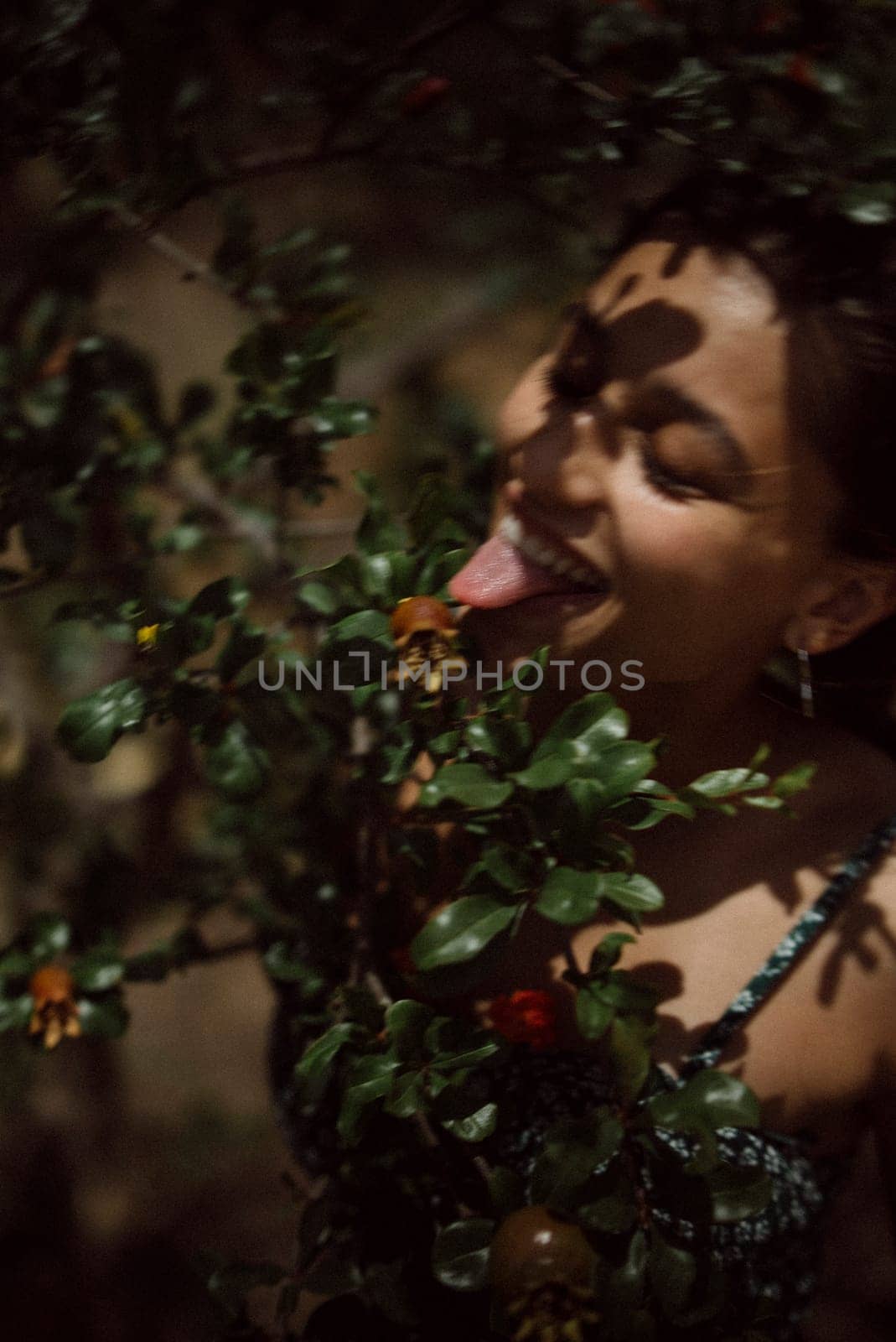 A woman blends with nature, joyfully licking a flower, embodying a carefree connection with the environment