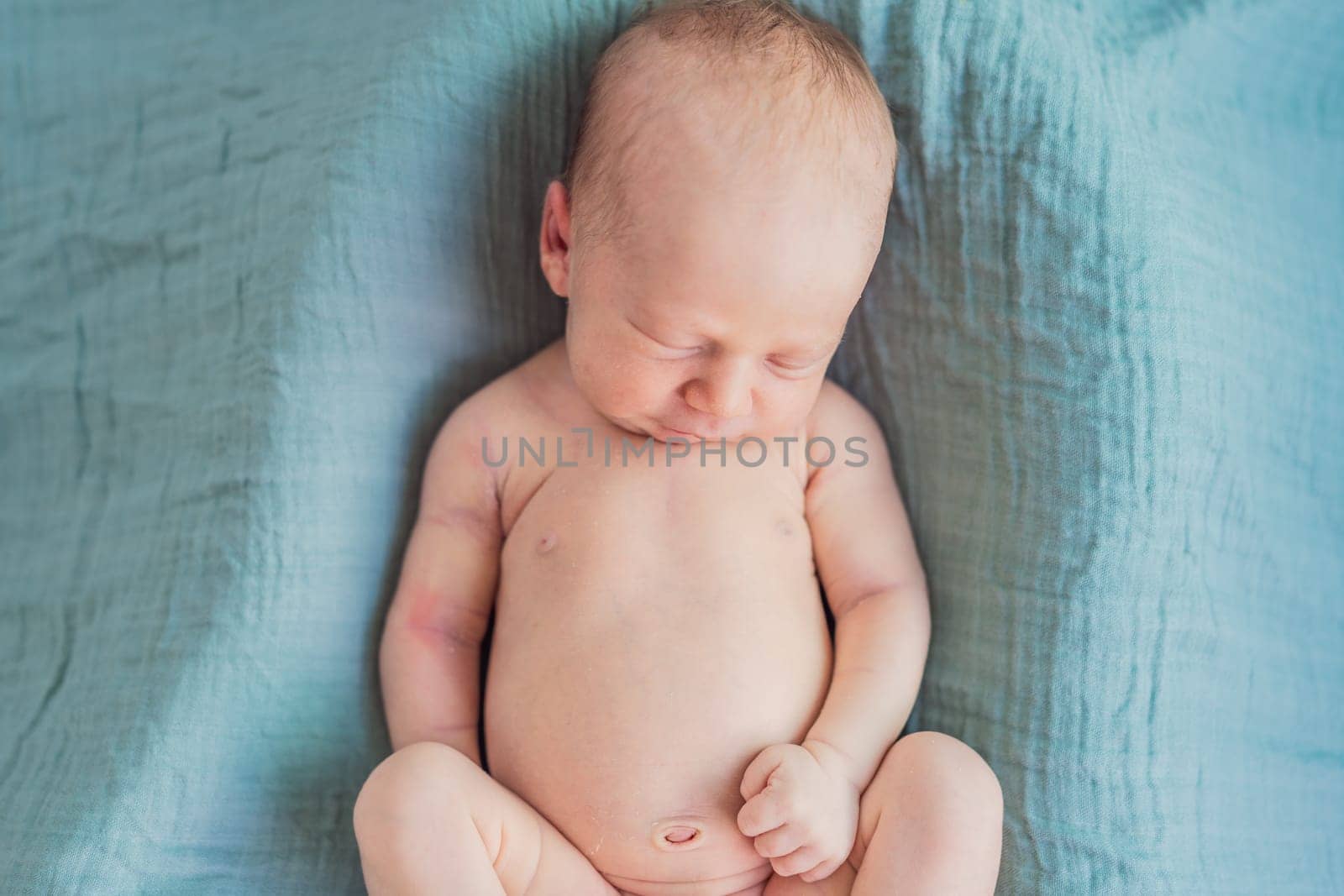 The baby is sleeping peacefully in his cozy nest. Newborn photo session captures the serene innocence and warmth of early moments.