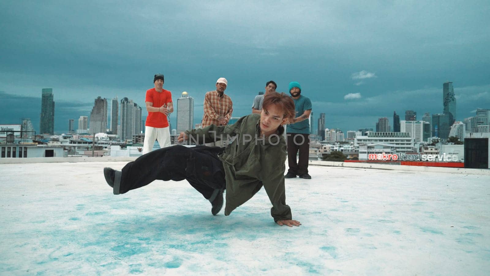 Hispanic hipster dancing surrounded by multicultural friend at city view with blue sky. Group of street dancer performing at rooftop. Active, fun, happy atmosphere. Outdoor sport 2024. Endeavor.