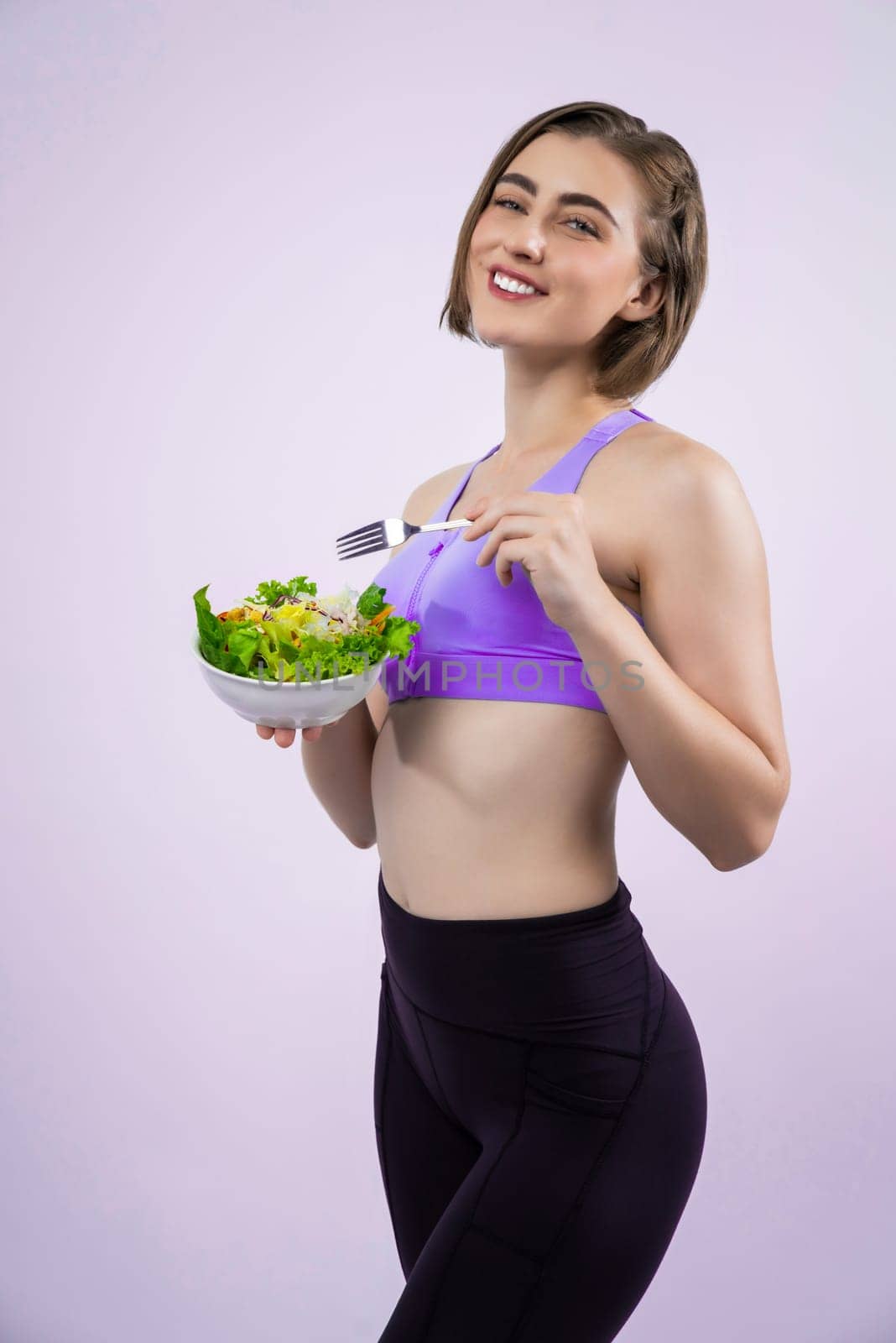 Full body length gaiety shot athletic and sporty young woman with healthy vegan food in standing posture on isolated background. Healthy active and body care by vegetarian lifestyle.