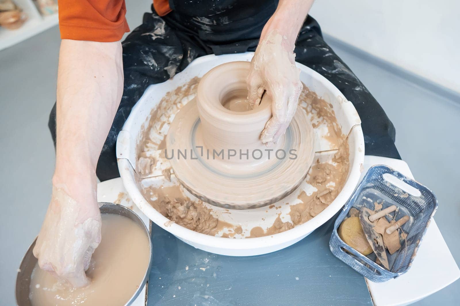 Close-up of a potter's hands working on a pottery wheel. by mrwed54