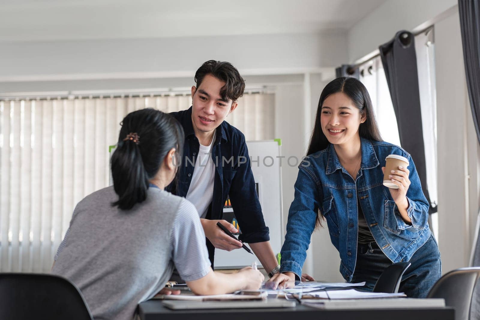 Diverse Team of Business Professionals Engaging in a Collaborative Discussion in a Modern Office Setting by wichayada