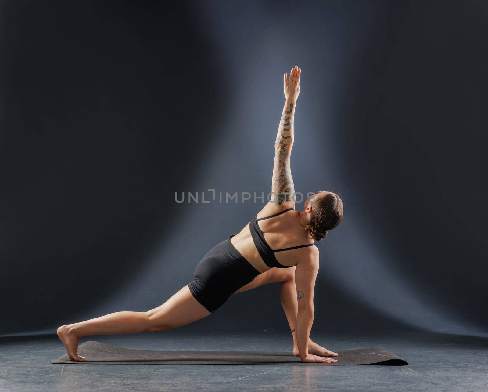 girl doing yoga and stretching, yoga and stretching poses on a dark background, yoga practice. fighting excess weight losing weight