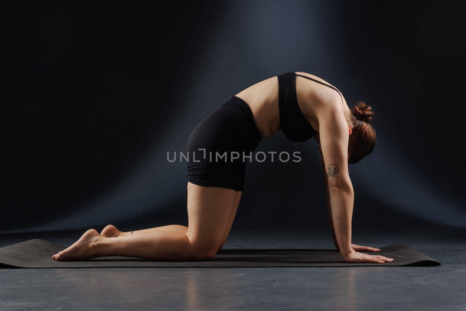 girl doing yoga and stretching, yoga and stretching poses on a dark background, yoga practice. fighting excess weight losing weight