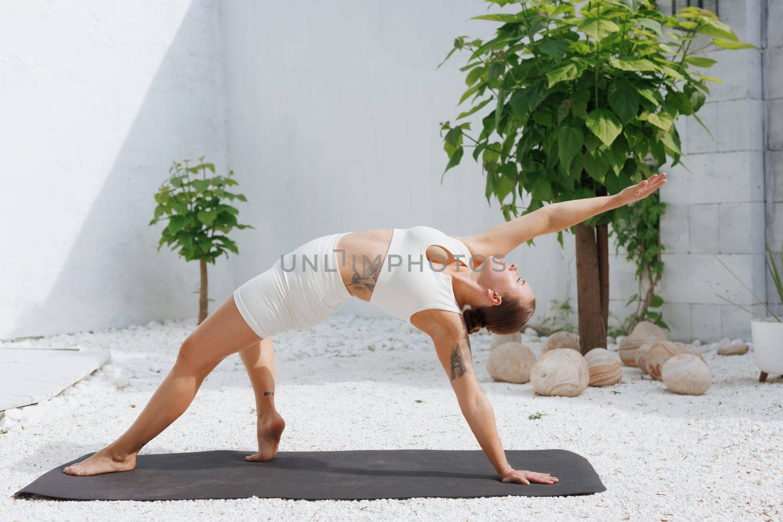 yoga stretching outdoors. side view of overweight woman practicing yoga on white background, body care concept, fighting excess weight losing weight