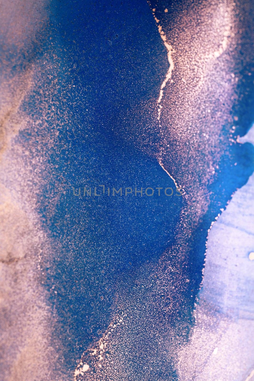 A close-up view of an abstract painting featuring swirling blue and gold hues against a white background. The artwork resembles a sky, water, or other natural element.
