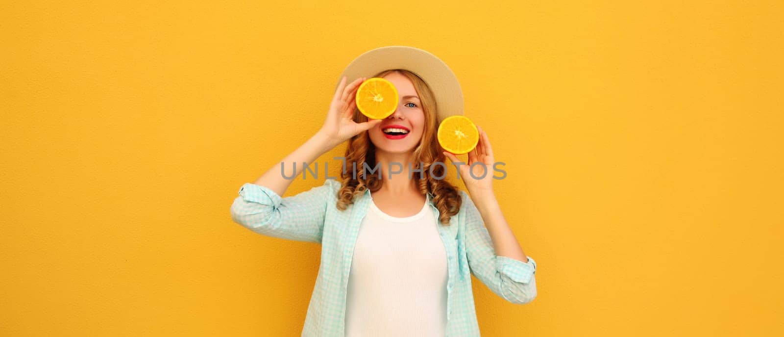 Summer portrait of happy joyful young woman with fresh slices of fresh orange fruits, cheerful girl smiles posing on bright yellow background