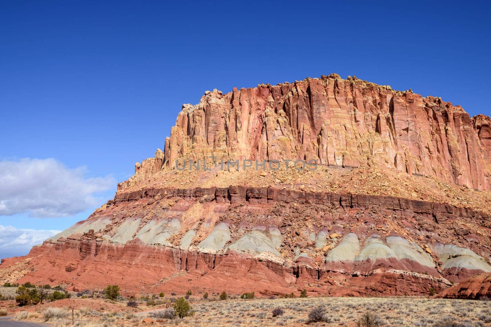 Breathtaking landscape shot of Waterpocket Fold geological rock layers in Capitol Reef National Park, Utah. Features rugged rock formations and vibrant colors under a clear blue sky - USA
