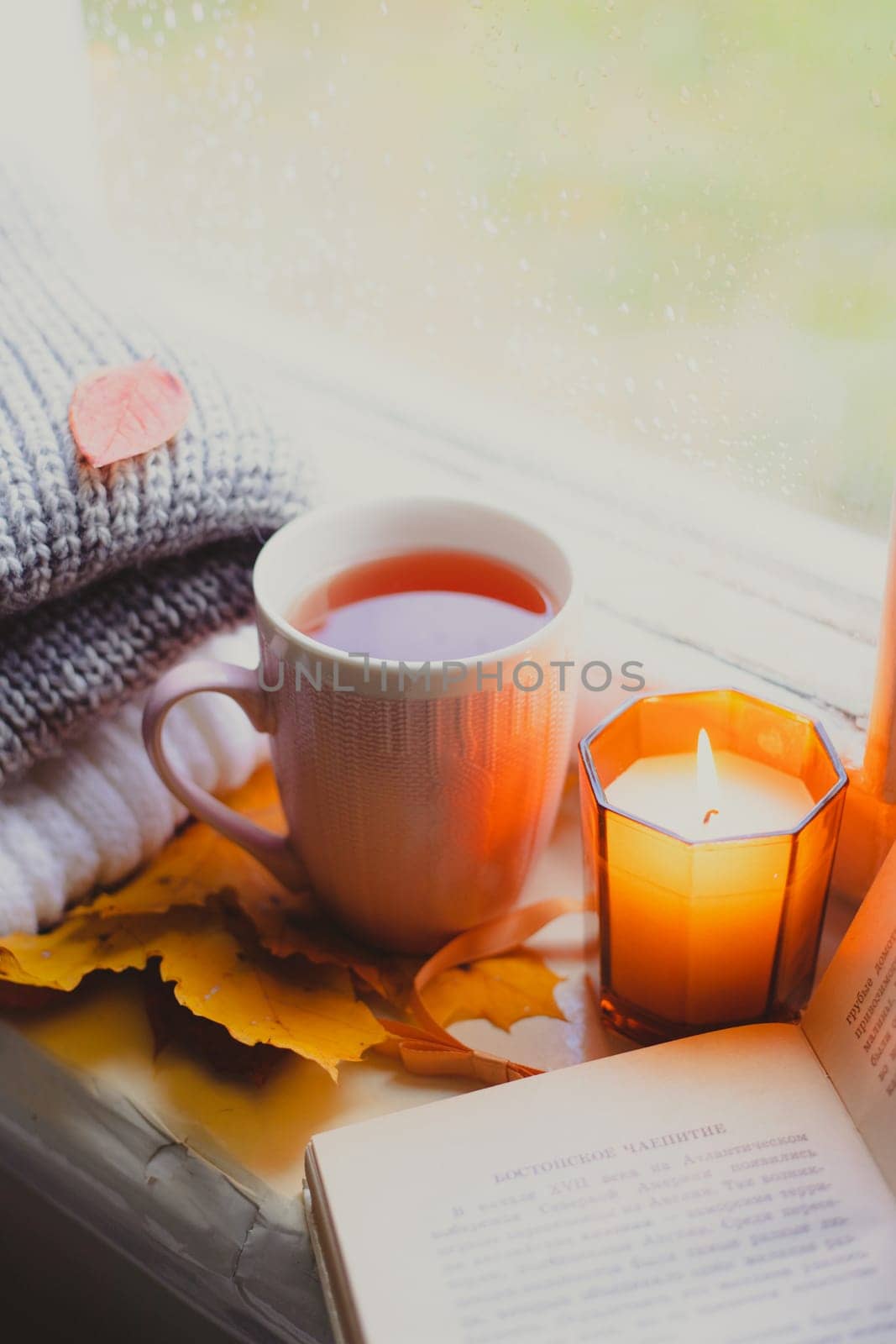 A burning candle on the window is autumn . the comfort of home . autumn comfort . autumn mood. The chondra .