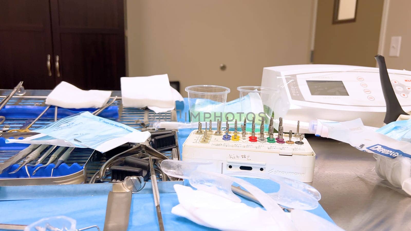 Denver, Colorado, USA-June 10, 2024-Slow motion-A table set with various sterilized surgical instruments, ready for a medical implant procedure. The organized setup includes forceps, scalpels, gauze, and syringes, emphasizing the precision and cleanliness required for implant surgery.