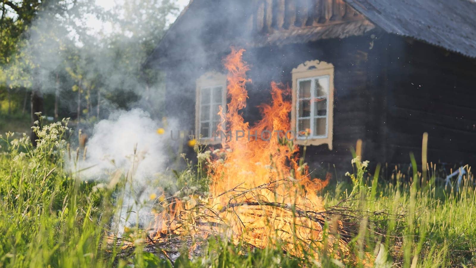 Burning branches outside the village house in eastern europe. by DovidPro