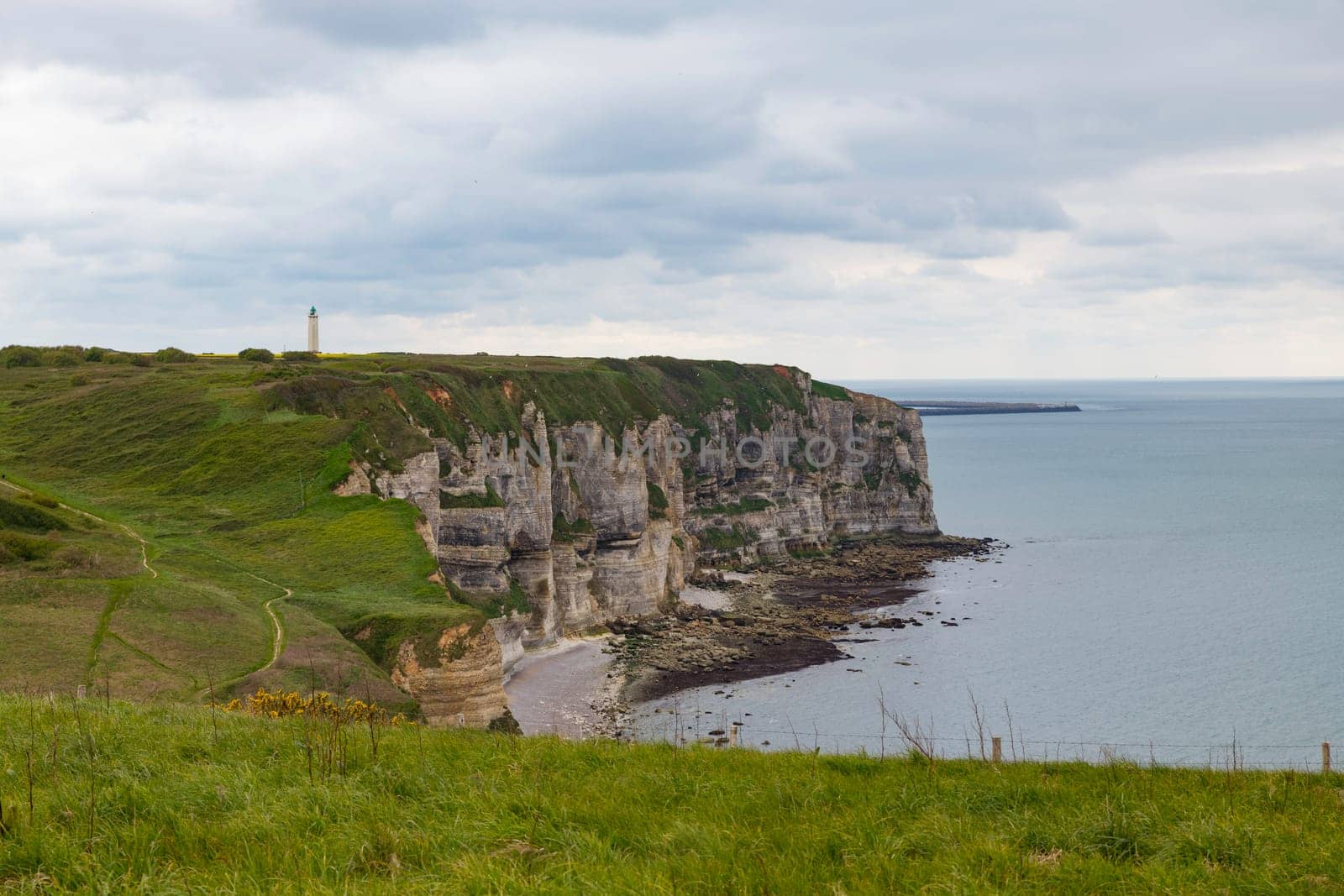 the chalk cliffs of le treport in France in Normandy with a blue sky with white clouds and the sea