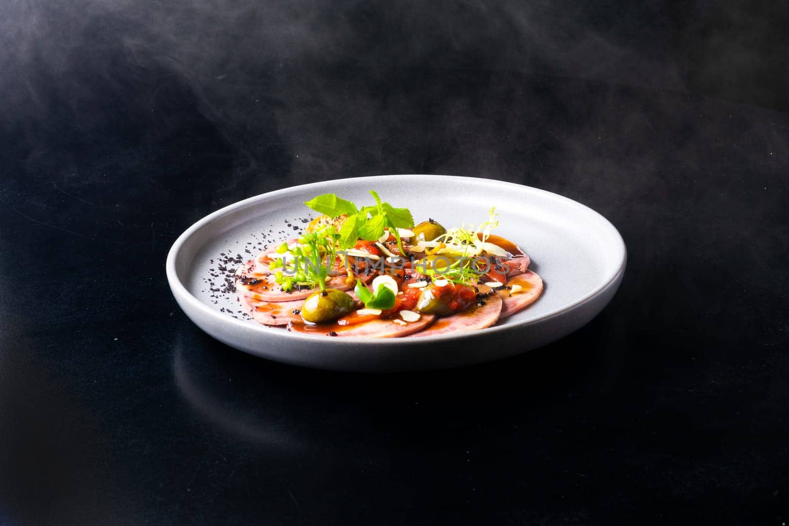 Beef tongue with sauce and vegetables on a white plate by Zelenin