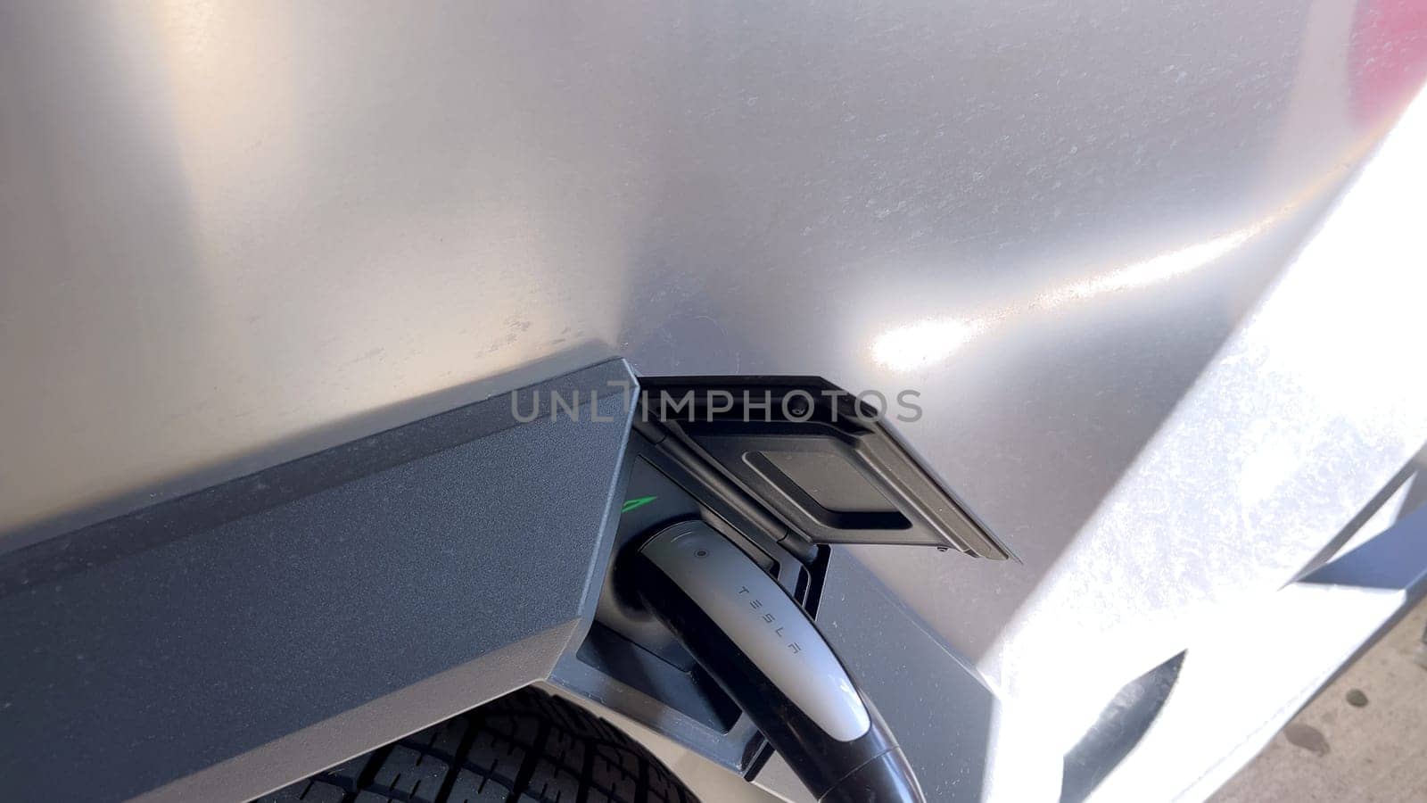 Pueblo, Colorado, USA-June 10, 2024-Slow motion-A Tesla Cybertruck is parked and charging at a Tesla Supercharger station in an underground parking garage. The futuristic design of the Cybertruck stands out against the industrial background.