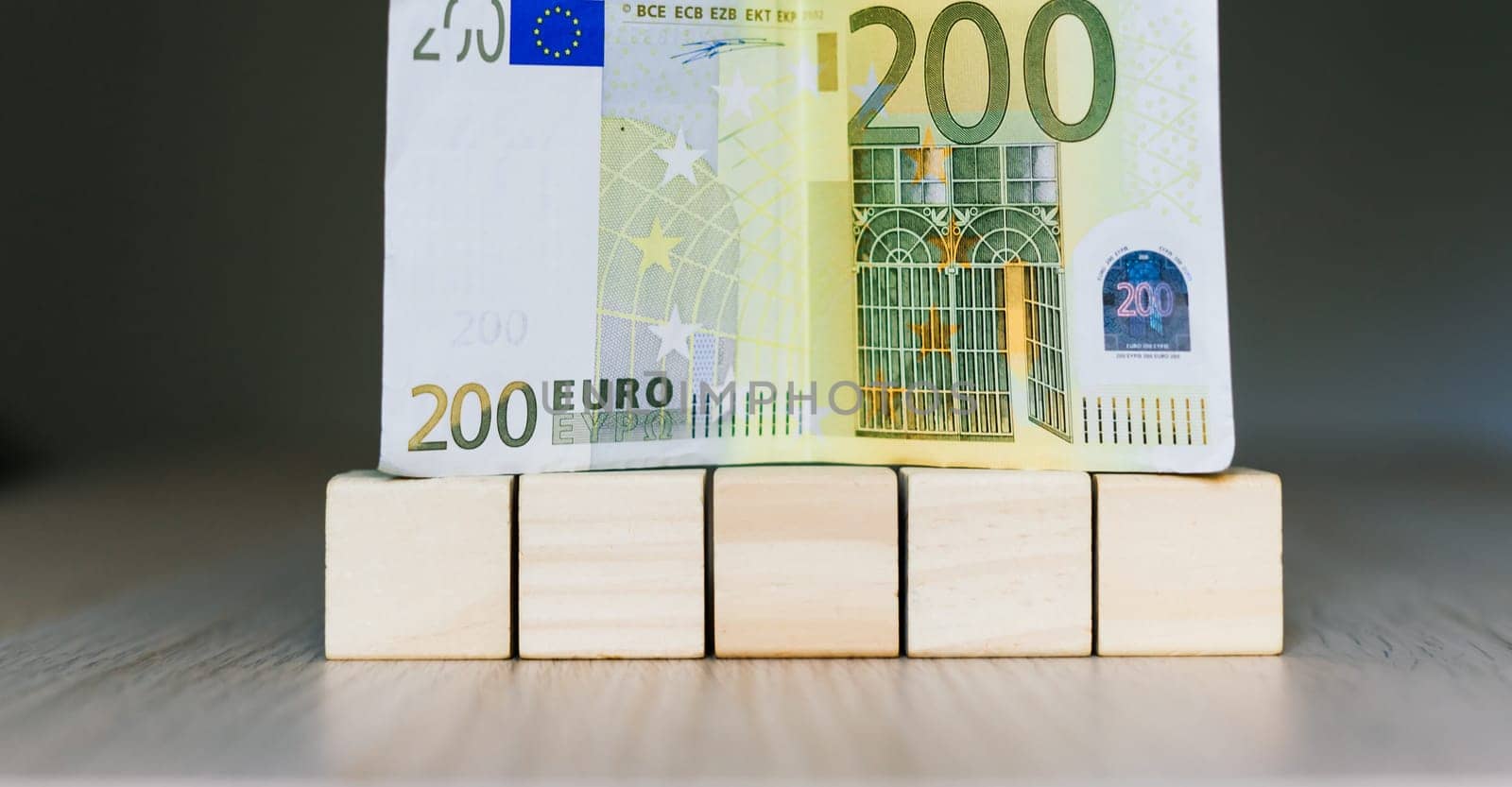 Wooden cubes blocks, money 200 Euro banknotes. Management big salary career conception