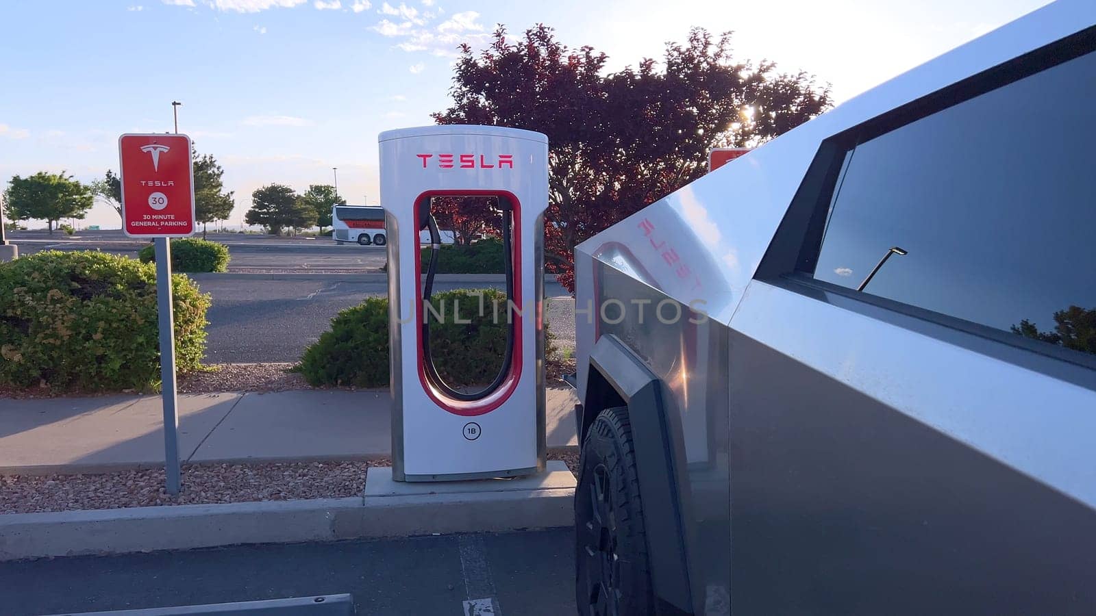 Tesla Cybertruck Charging at Outdoor Supercharger Station by arinahabich